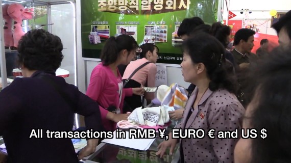 A woman holds a U.S. dollar bill at the Pyongyang Spring International Trade Fair 2014 (Photo: North Korea Tech/Aram Pan)