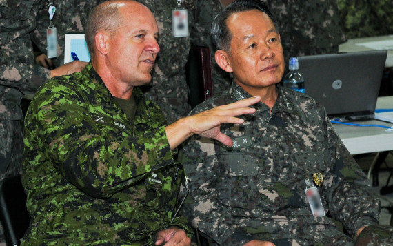 Admiral Choi Yoon Hee, Chairman of Joint Chiefs of Staff for the Republic of Korea, is briefed by Maj. Gen. Dean Milner, 1st Canadian Division Commanding General, about the operations at the 1st Canadian Division joint operation center in preparation for Ulchi Freedom Guardian exercise at Camp Yongin, South Korea, Aug. 20. (DOD Photo / Daniel Schroeder)