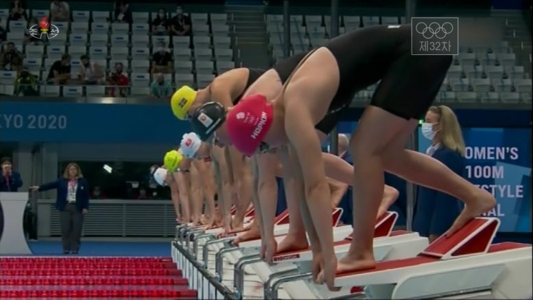 Image is a screenshot of TV coverage showing a swimming event about to start.